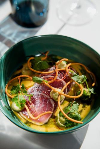a green bowl of food with meat and vegetables at Les Mazots du Clos in Villars-sur-Ollon