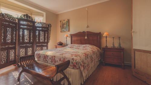 a bedroom with a bed and a wooden chair at De Brugdraaier - The Bridge Turner in Neerpelt