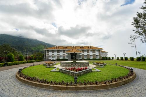 a large building with a fountain in front of it at Le Montfort Resort in Munnar
