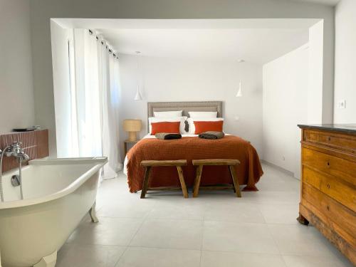 - une chambre blanche avec un lit et une baignoire dans l'établissement Clos Mahistre, Studio 4 étoiles, clim & piscine, à Nîmes