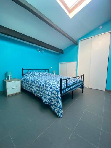 une chambre avec un lit dans une pièce aux murs bleus dans l'établissement L'Halevy- Appartement avec Garage proche gare et centre commercial Polygone Beziers- Wifi, à Béziers