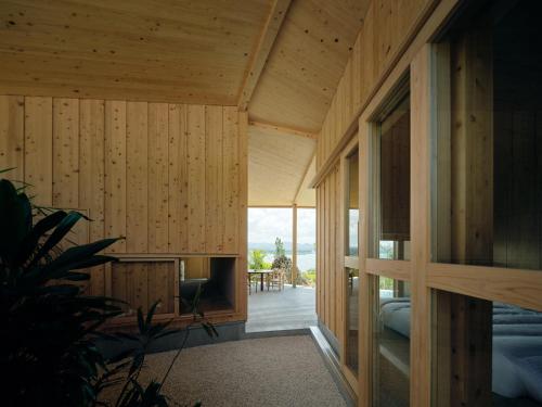 a room with wood paneled walls and a door to a patio at YAWN YARD Kouri Island in Kouri
