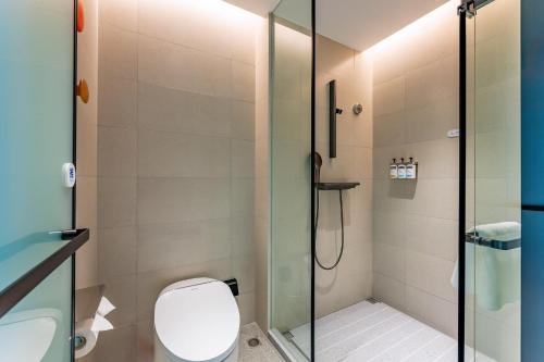 a bathroom with a toilet and a glass shower at Holiday Inn Express Shanghai Jing'an Temple by IHG in Shanghai