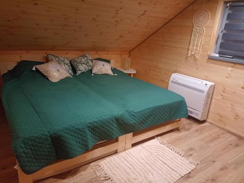 a bedroom with a green bed in a cabin at Chatka Karpatka in Kostrzyca