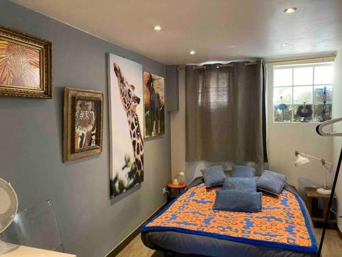 une chambre avec un lit avec des oreillers bleus dessus dans l'établissement Maison terrasse et jardin à proximité de Paris, à LʼHay-les-Roses