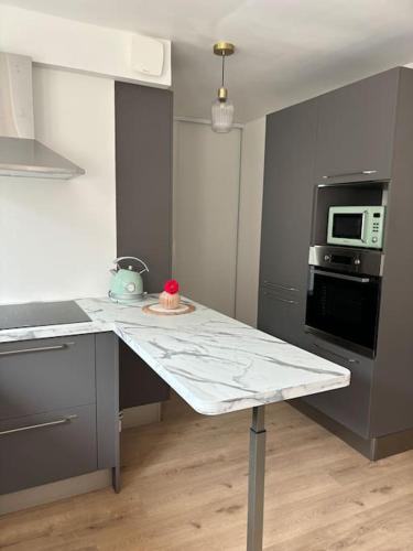 - une cuisine avec un comptoir blanc dans une pièce dans l'établissement Maison entière 4 chambres, à Le Blanc