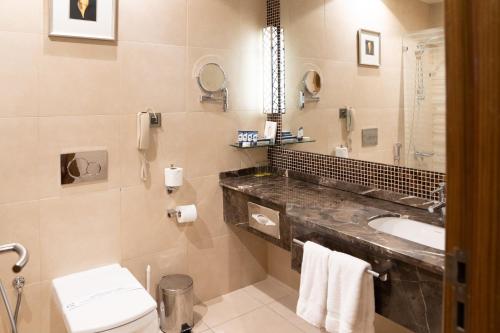 a bathroom with a sink and a toilet at Golden Tulip Hotel Buraidah Al Qassim in Buraydah