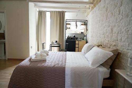 a bedroom with a white bed with towels on it at Wanderlust in Sannicandro di Bari