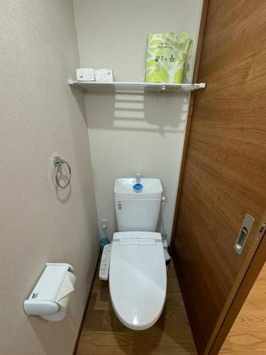 a small bathroom with a toilet and a door at 木香の家-天下茶屋 in Osaka
