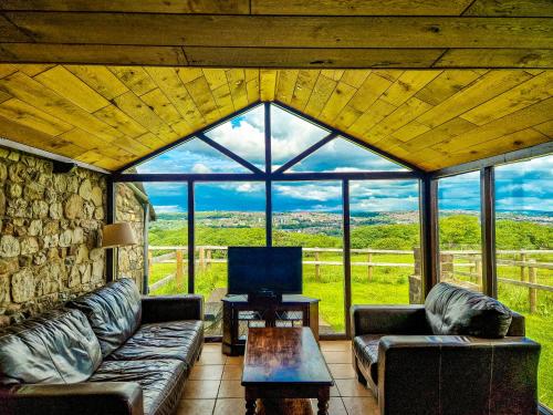 a living room with couches and a large window at Clyne Farm Centre in The Mumbles