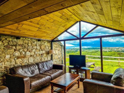 a living room with a couch and a large window at Clyne Farm Centre in The Mumbles