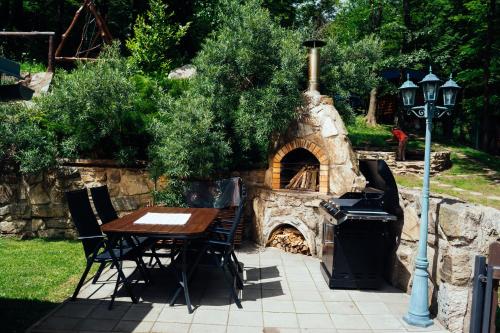 a table and chairs sitting around a stone oven at Chata POHÁDKA- "Lesni Udoli" in Pürstein