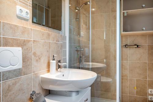 a bathroom with a white sink and a shower at Apartment Im Schwedenhaus in Kiel