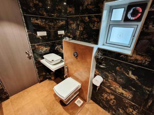 a small bathroom with two toilets and a window at Hotel Pearl Residency Thane in Thane