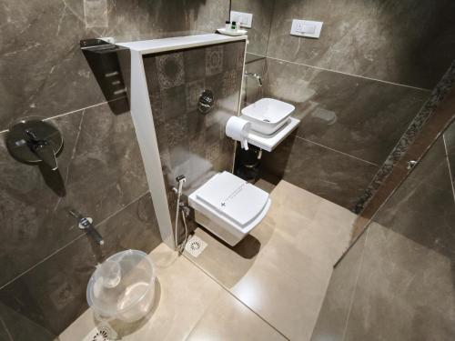 a bathroom with a toilet and a sink at Hotel Pearl Residency Thane in Thane