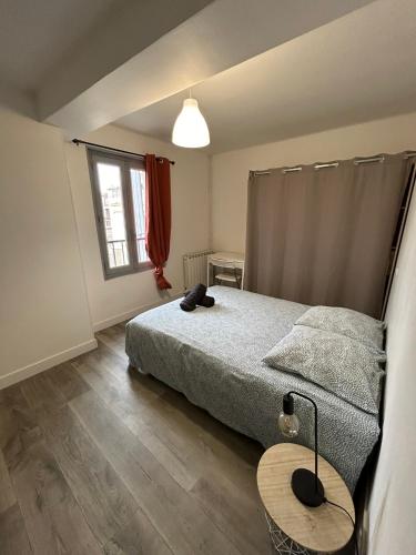 une chambre avec un lit, une table et une fenêtre dans l'établissement 8 Aout 3-Spacieux appartement 3 chambres - Allée Paul Riquet - Wifi - Tv connecté, à Béziers