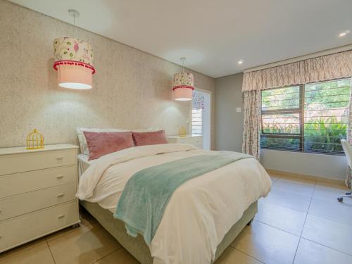 a bedroom with a large bed and two pendant lights at 4onJuweel in Four Ways