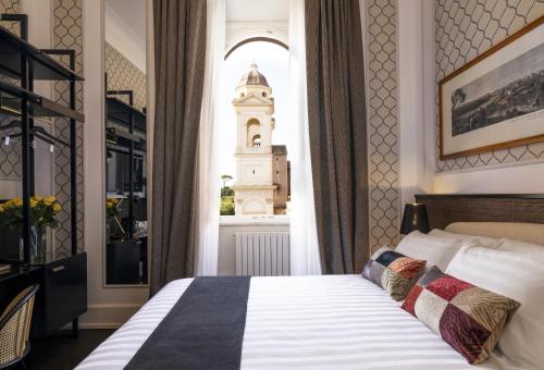 a bedroom with a bed and a window with a clock tower at Hotel Scalinata Di Spagna in Rome