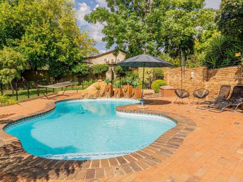 a swimming pool with chairs and an umbrella at 4onJuweel in Four Ways