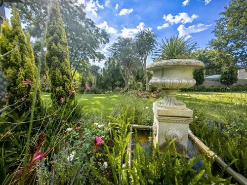 a garden with a stone urn in the middle at 4onJuweel in Four Ways
