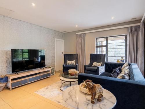 a living room with a blue couch and a tv at 4onJuweel in Four Ways