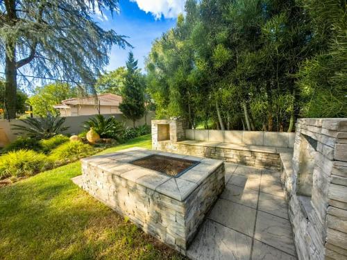 a backyard with a stone fire pit in the grass at 4onJuweel in Four Ways