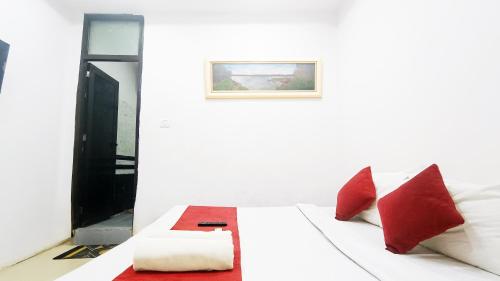 a white bed with red pillows in a room at Hotel Maharaja Inn - Lajpat Nagar I in New Delhi