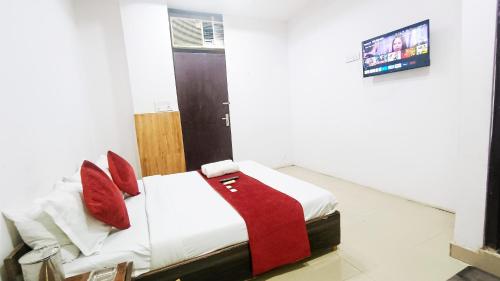 a bedroom with a bed with red pillows on it at Hotel Maharaja Inn - Lajpat Nagar I in New Delhi