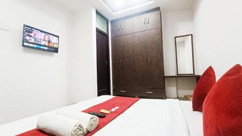 a bedroom with a bed and two red chairs at Hotel Maharaja Inn - Lajpat Nagar I in New Delhi