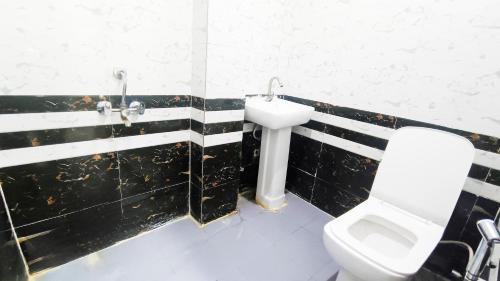 a bathroom with a toilet and a sink at Hotel Maharaja Inn - Lajpat Nagar I in New Delhi