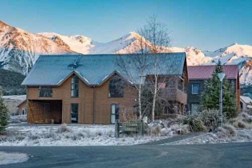 a large house with snow covered mountains in the background at Royale on Cheese in Castle Hill