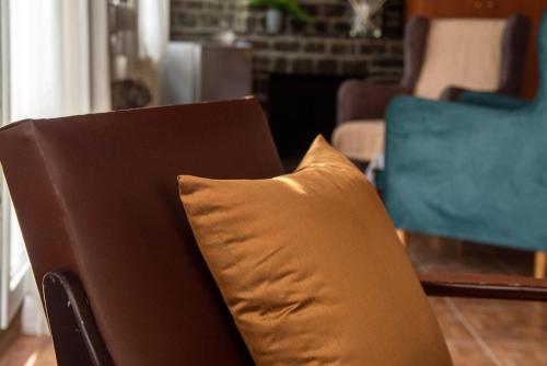 a brown couch with a pillow in a living room at Hôtel Argo in Volos