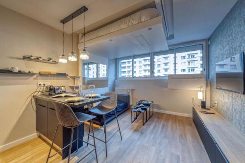 une cuisine et un salon avec une table et des chaises dans l'établissement R'Apparts Studio Luxury N 9, à Grenoble