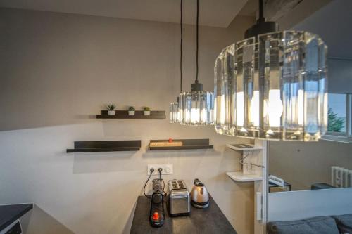 une cuisine avec un comptoir avec deux bouteilles et des lustres dans l'établissement R'Apparts Studio Luxury N 9, à Grenoble