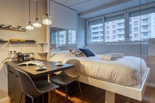 - une chambre avec un lit et un bureau avec des chaises dans l'établissement R'Apparts Studio Luxury N 9, à Grenoble
