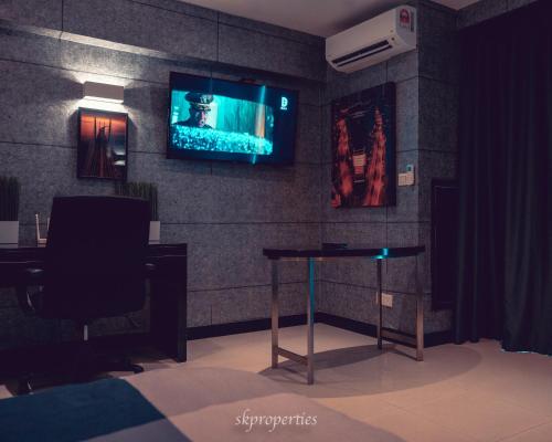 a room with a table and a tv on a wall at Seaview Suites at Admiral Bay in Port Dickson