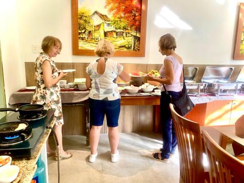 drie vrouwen staan in een keuken eten te bereiden bij De Vivre Hoi An Hotel in Hội An
