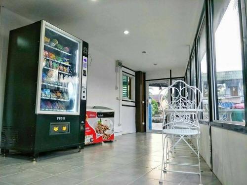 a white chair sitting in front of a refrigerator at Pichayapa Place in Ban Pa Sang (1)