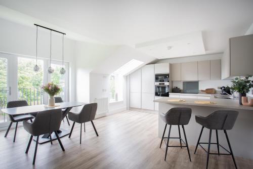 a kitchen and dining room with a table and chairs at Penthouse Apartment at Loch Lomond with 2 bedrooms in Balloch