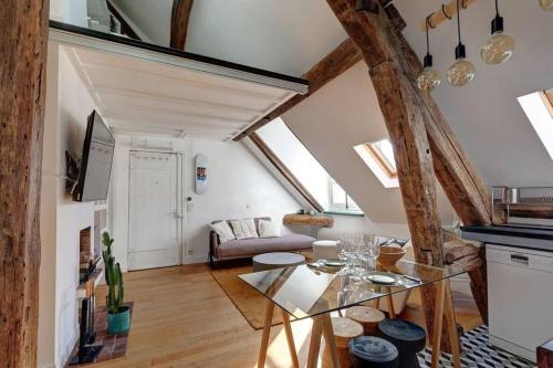 un salon avec une table en verre et un canapé dans l'établissement Loft place des Vosges, à Paris