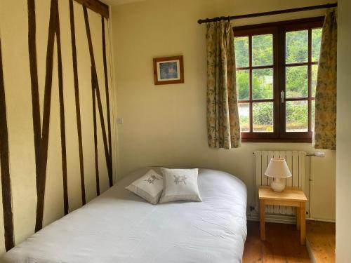 une chambre avec un lit blanc avec une fenêtre dans l'établissement Maison normande au cœur de Le Bec-Hellouin, au Bec-Hellouin