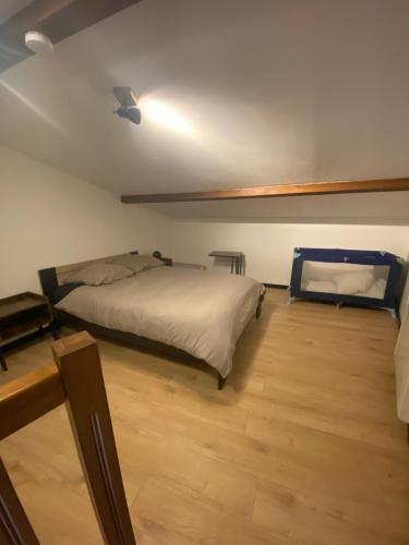 une chambre avec deux lits et un parquet dans l'établissement Petite maison de charme, à Saint-Rambert-en-Bugey