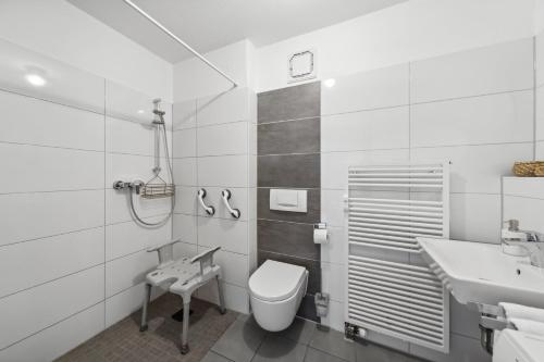 a white bathroom with a toilet and a sink at Barrierefrei - Privatparkplatz - zentral im Grünen in Magdeburg