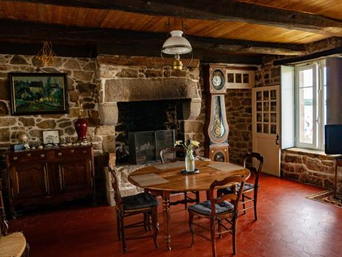 une salle à manger avec une table et une cheminée en pierre dans l'établissement Villa Aman An Ty, à Belz