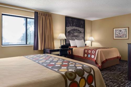 a hotel room with two beds and a window at Super 8 by Wyndham Dyersville in Dyersville