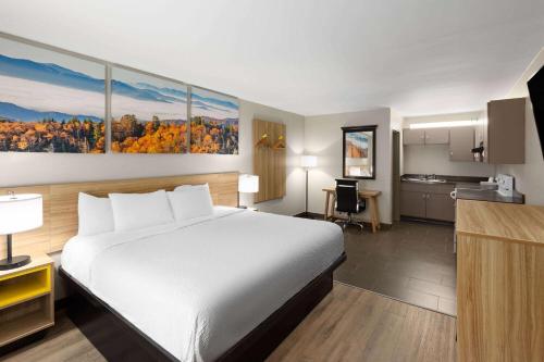 a hotel room with a bed and a kitchen at Days Inn by Wyndham Clarksville North EXIT 4 in Clarksville
