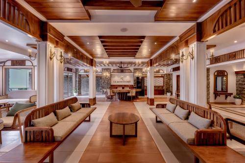 a living room with couches and a table at Le Montfort Resort in Munnar