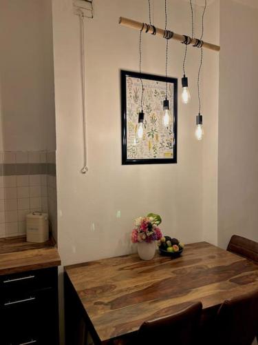 a kitchen with a wooden table with a vase of fruit at Haus Violla in Ludwigsfelde