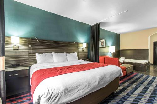 a hotel room with a large bed and a bathroom at Comfort Suites Fairgrounds West in Oklahoma City