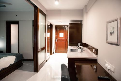 a hotel room with a sink and a bedroom at Seaview Suites at Admiral Bay in Port Dickson
